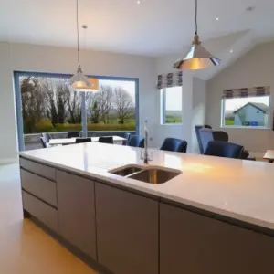 Modern kitchen with island and large windows.